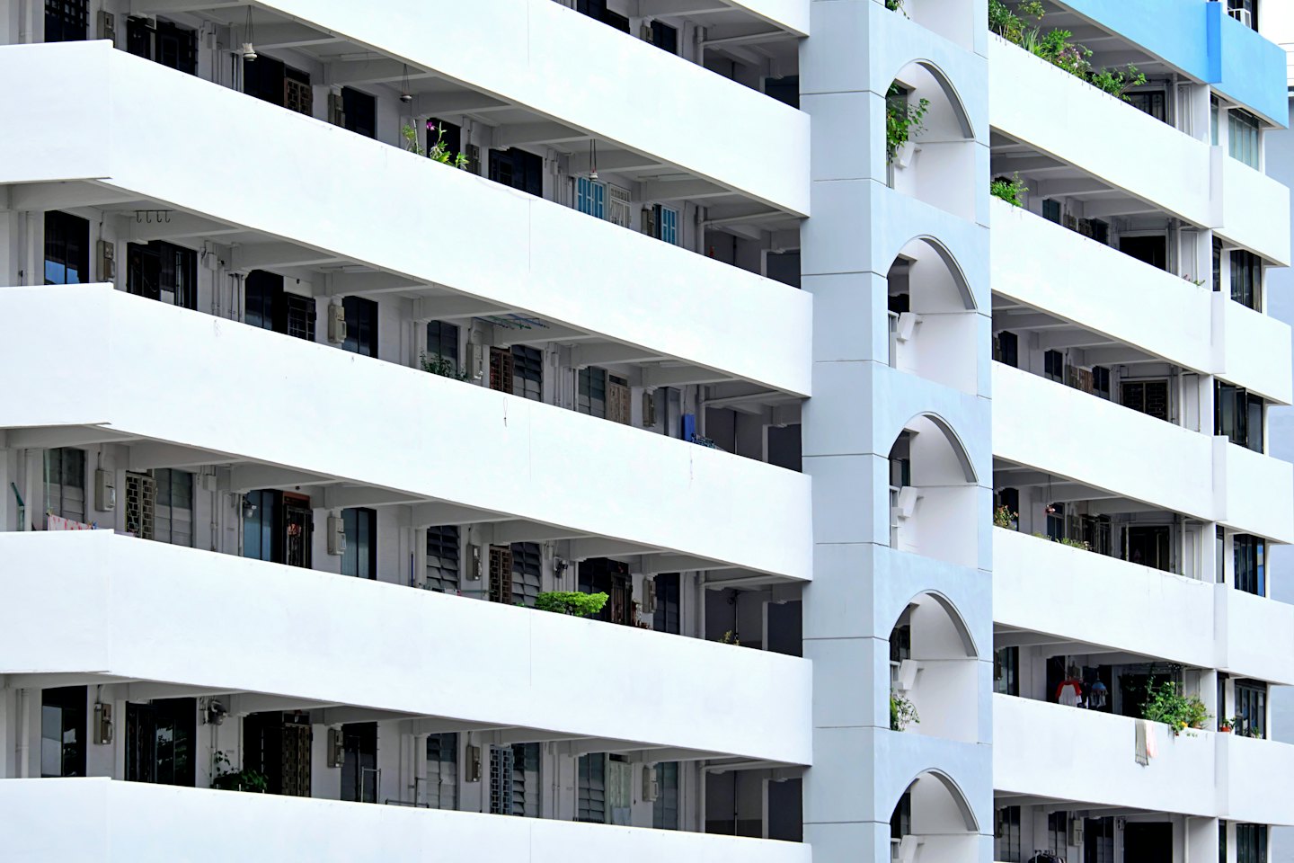 Moderno condominio con balconi bianchi e dettagli di design ad arco.
